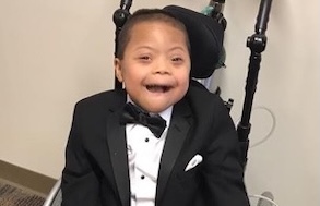 Boy in a tuxedo sitting in a wheel chair