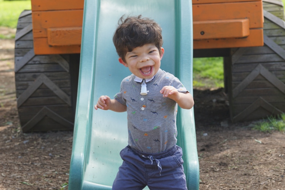 Boy standing up in front of slide in a park