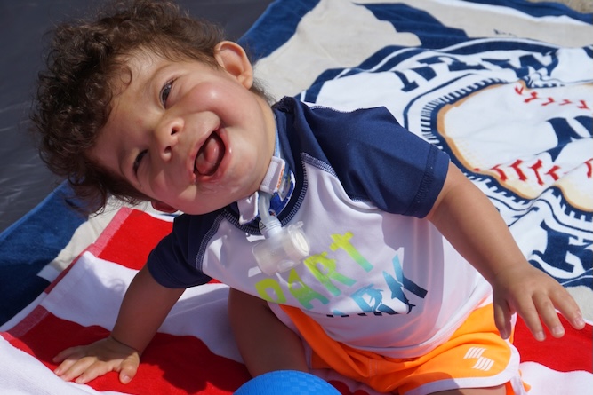 Little boy in a swimsuit sitting on a towel