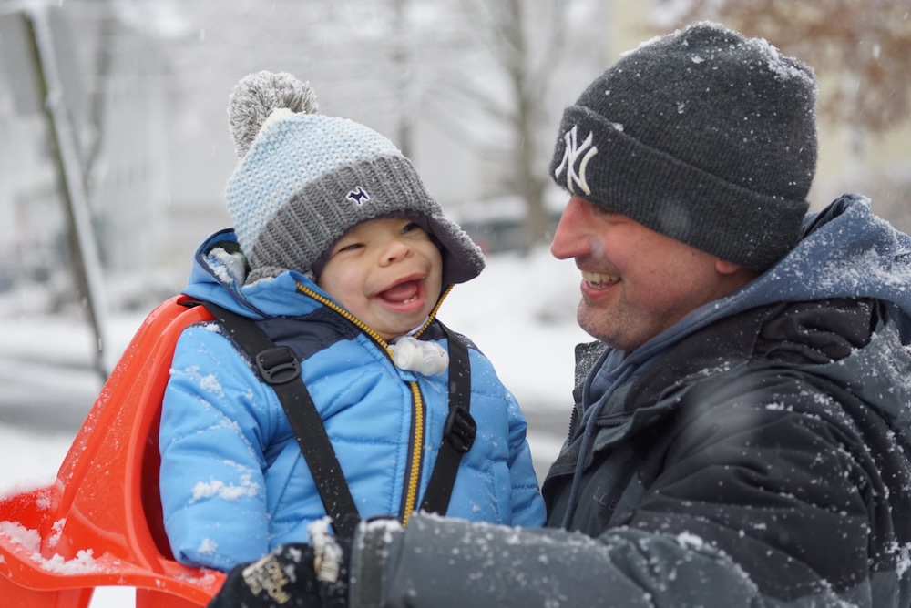 Man holding boy outside in the snow