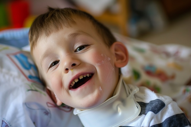 Little boy with a tracheostomy tube lying down